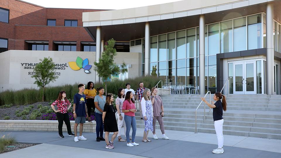 A 赌钱app可以微信提现 admissions representative leading a group tour in front of the student center.